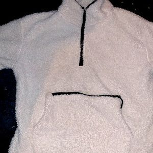 A white fluffy sweater with a tip in pocket and it’s been worn